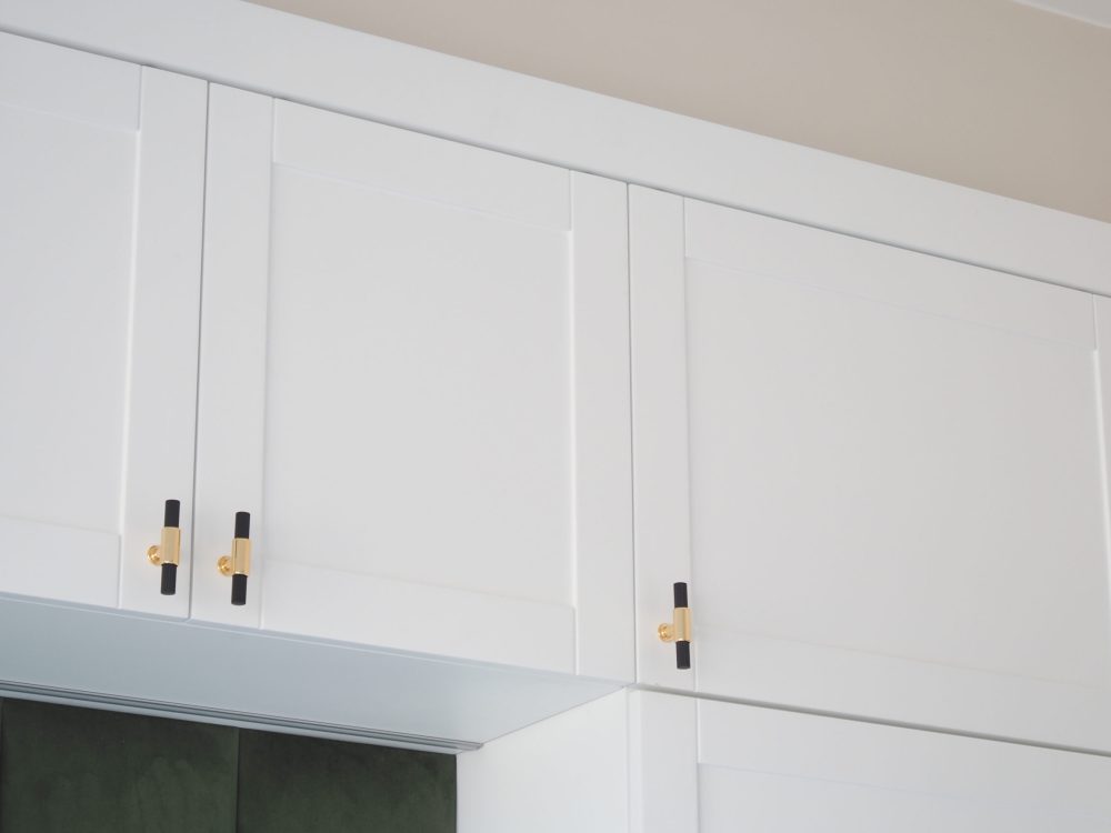 Stylish white cabinets adorned with chic gold handles, perfect for modern kitchens.